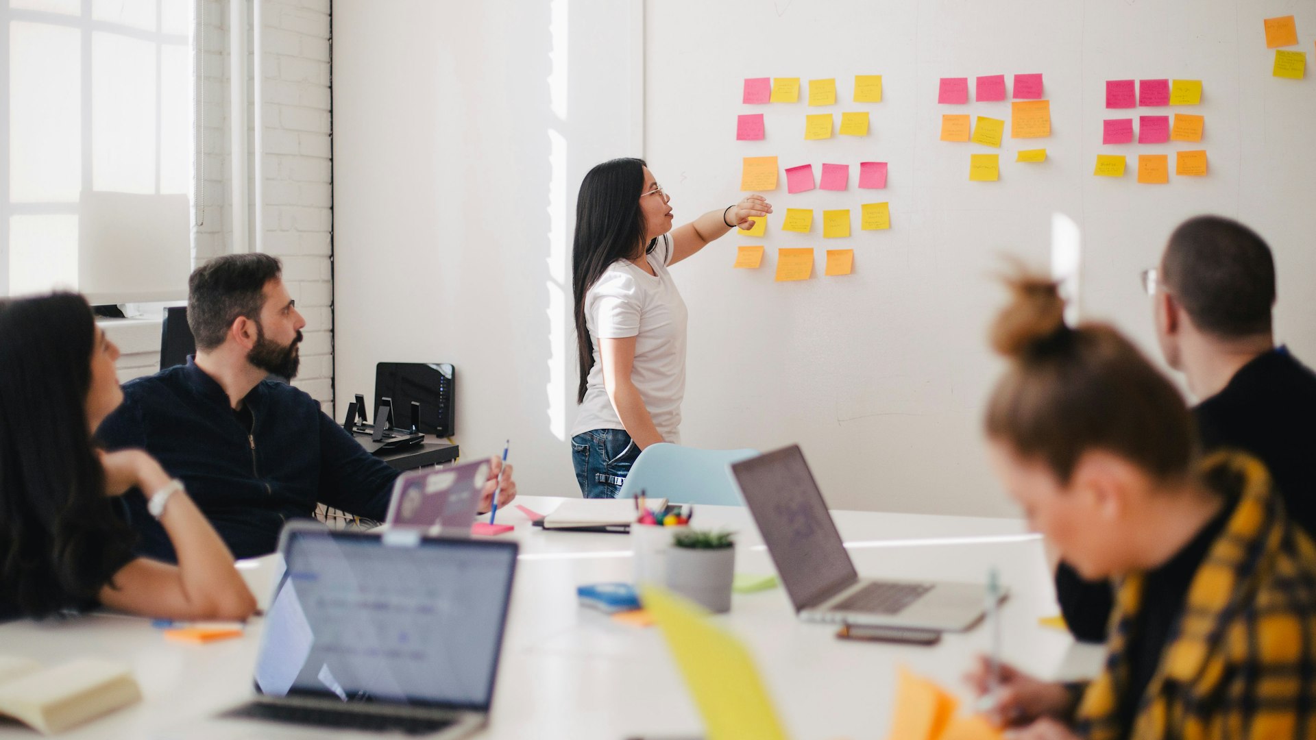 Product team planning roadmap with sprint cards and Kanban board in modern tech office